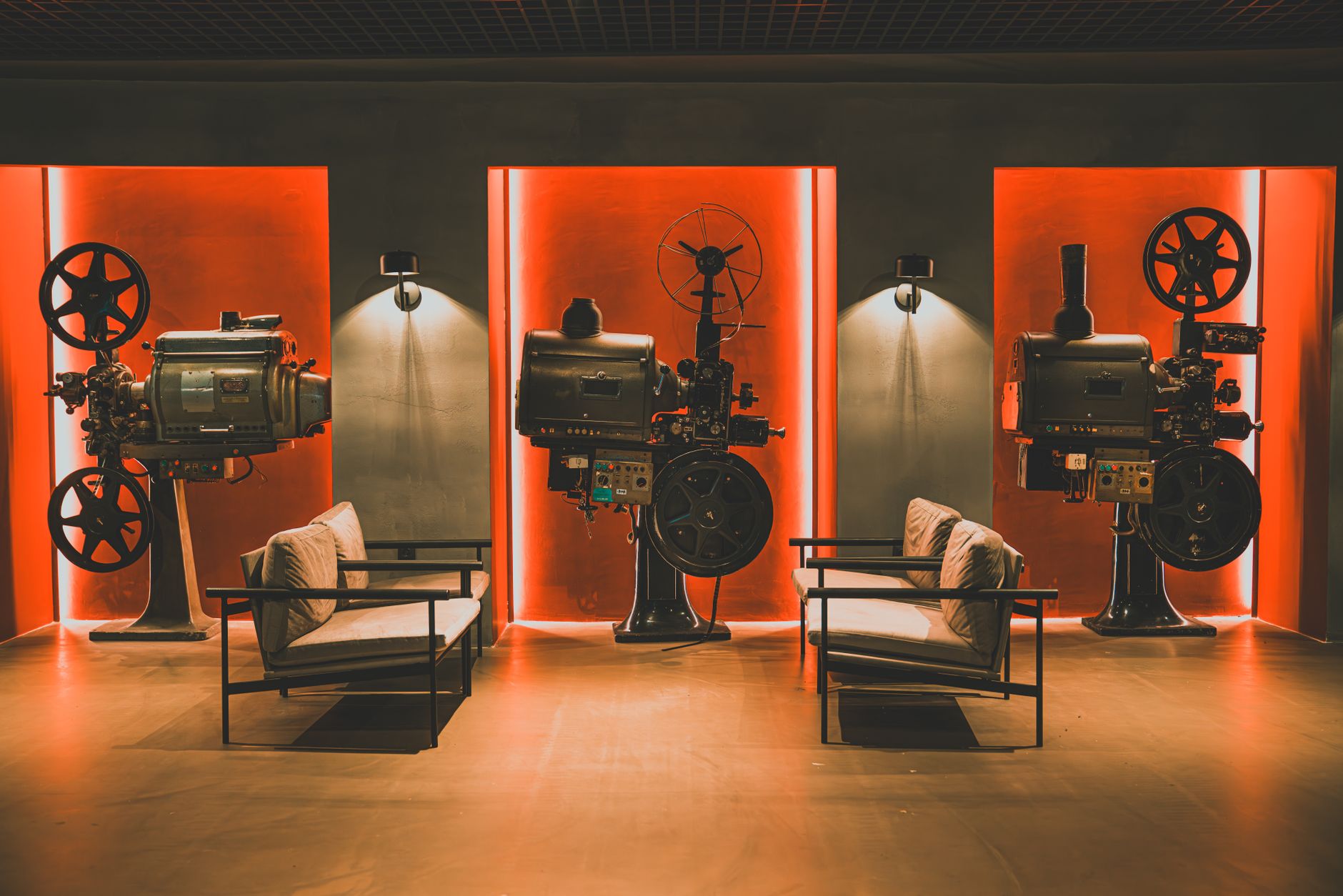 Sala cinematografica con schermo illuminato e poltrone rosse