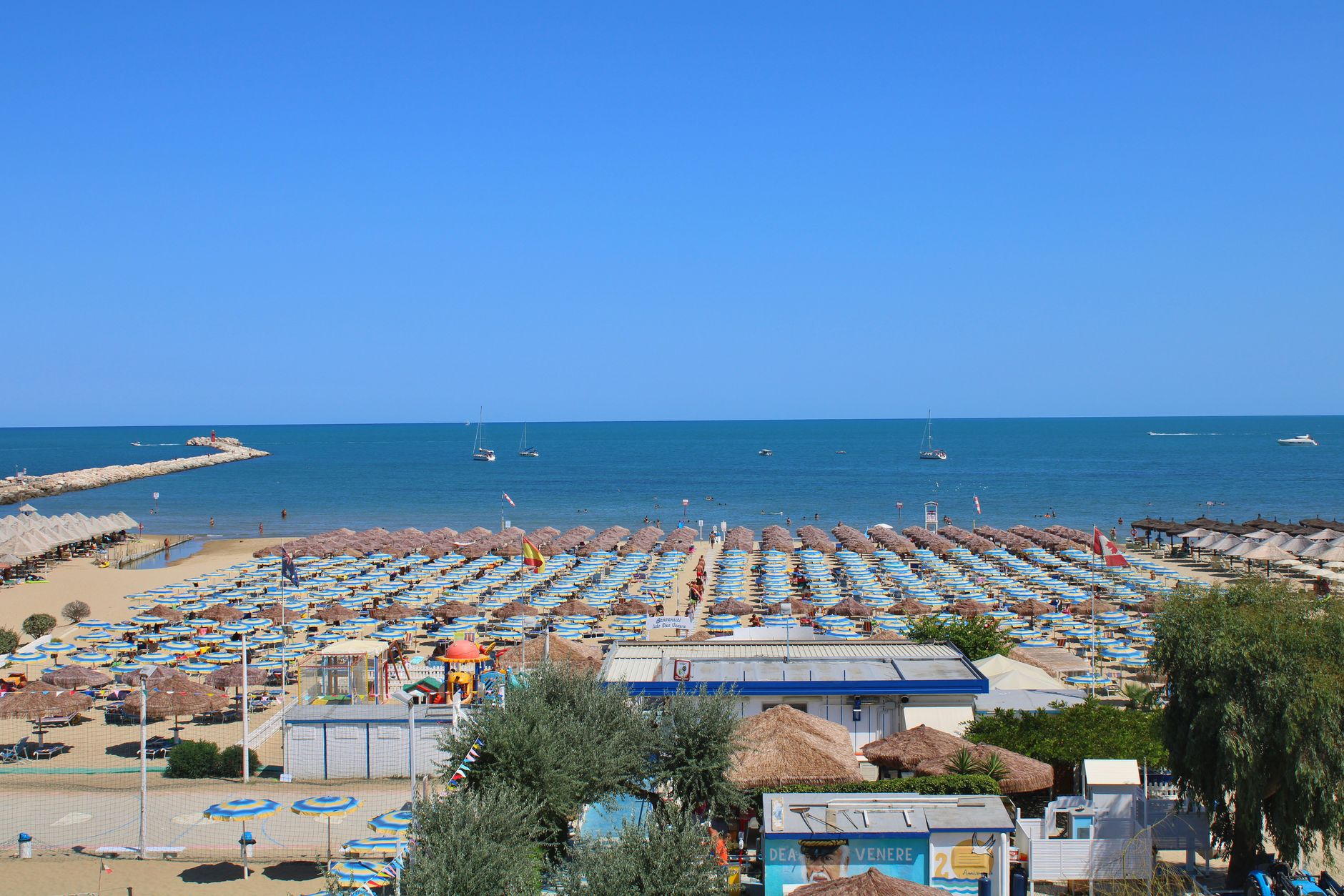 Costa italiana con mare e ombrelloni a metà agosto