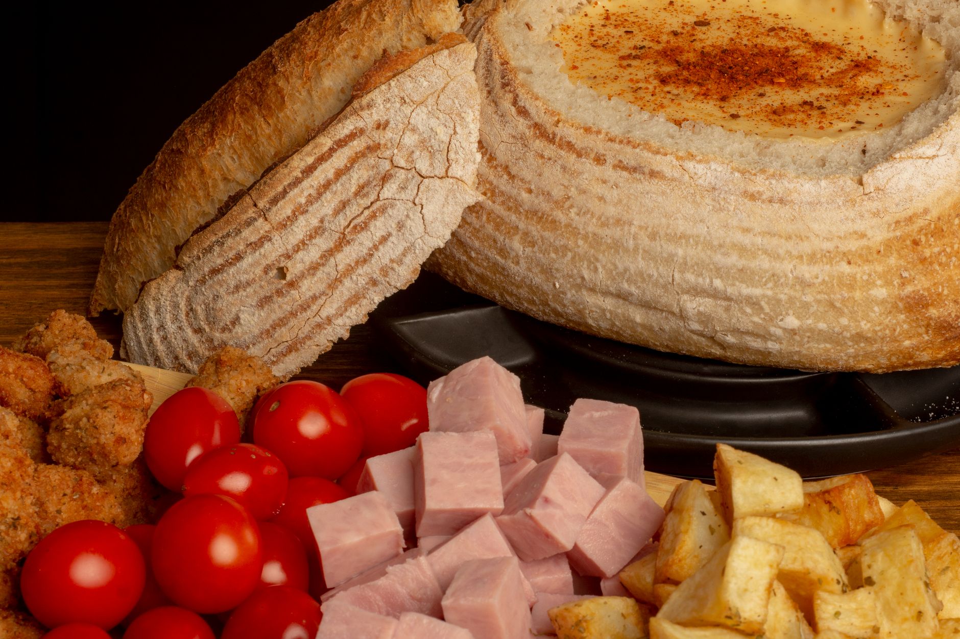 Un pentolino di fondue di formaggio fuso al centro della tavola