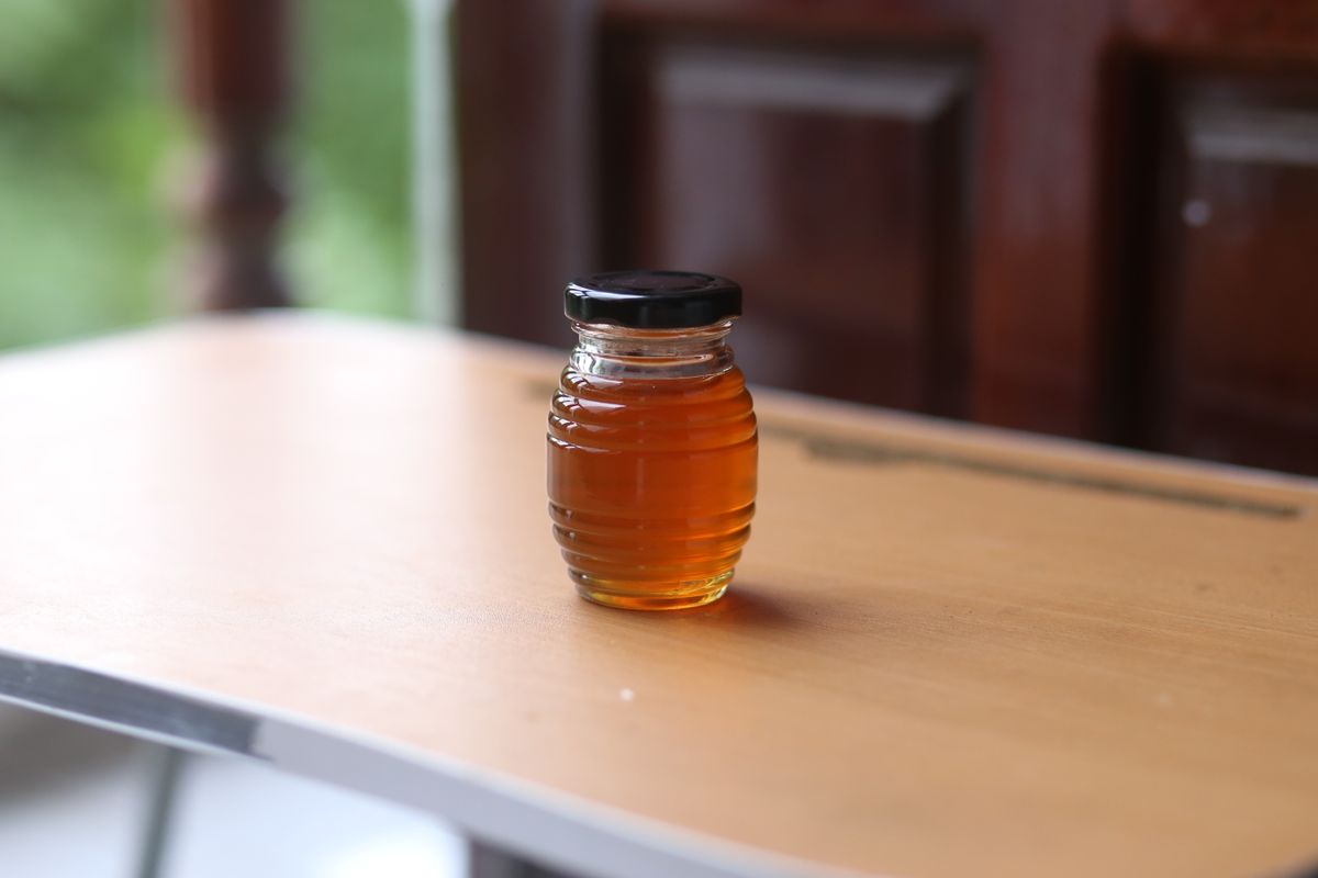 Miele che cola da un cucchiaio di legno