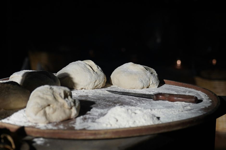 Mani che lavorano un impasto di pane sviluppando il glutine