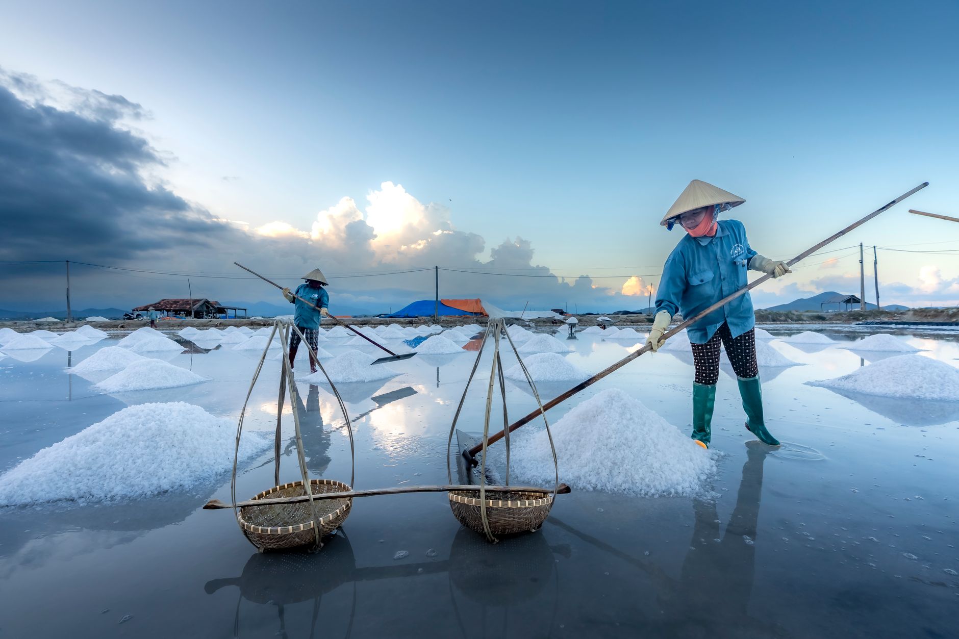 Manciata di sale marino tra le mani sopra saline