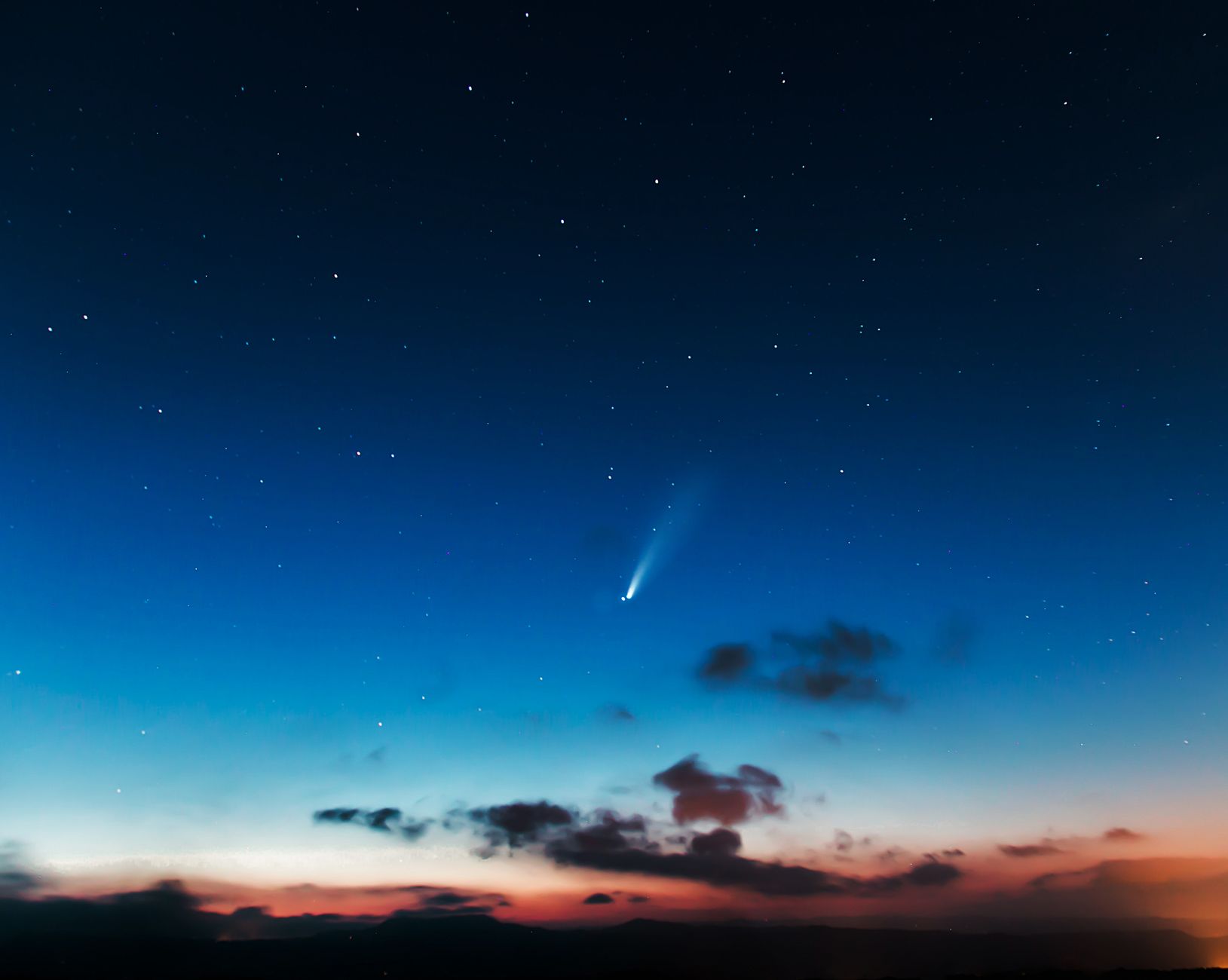 Cometa luminosa con la sua coda nello spazio profondo