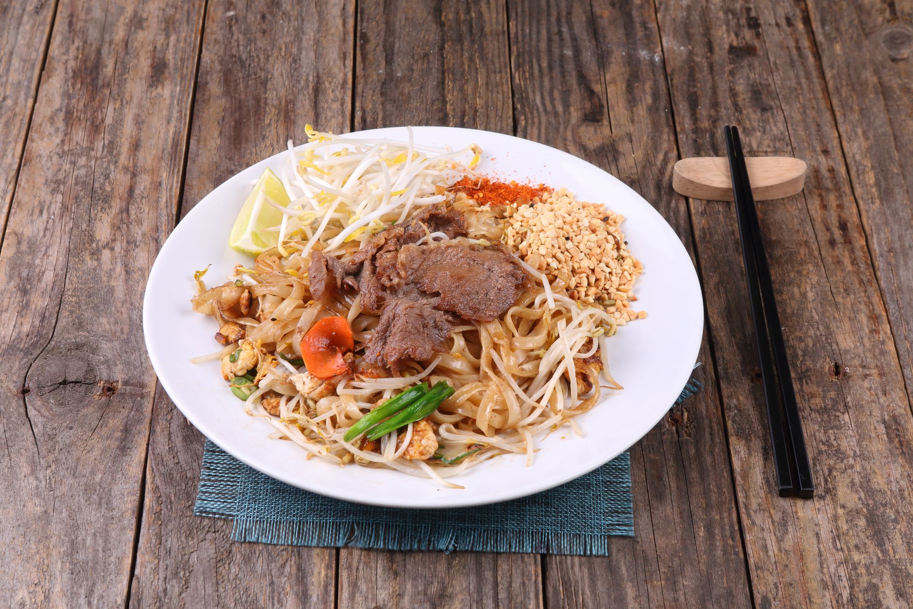 Piatto di pad thai con noodles di riso, arachidi e lime
