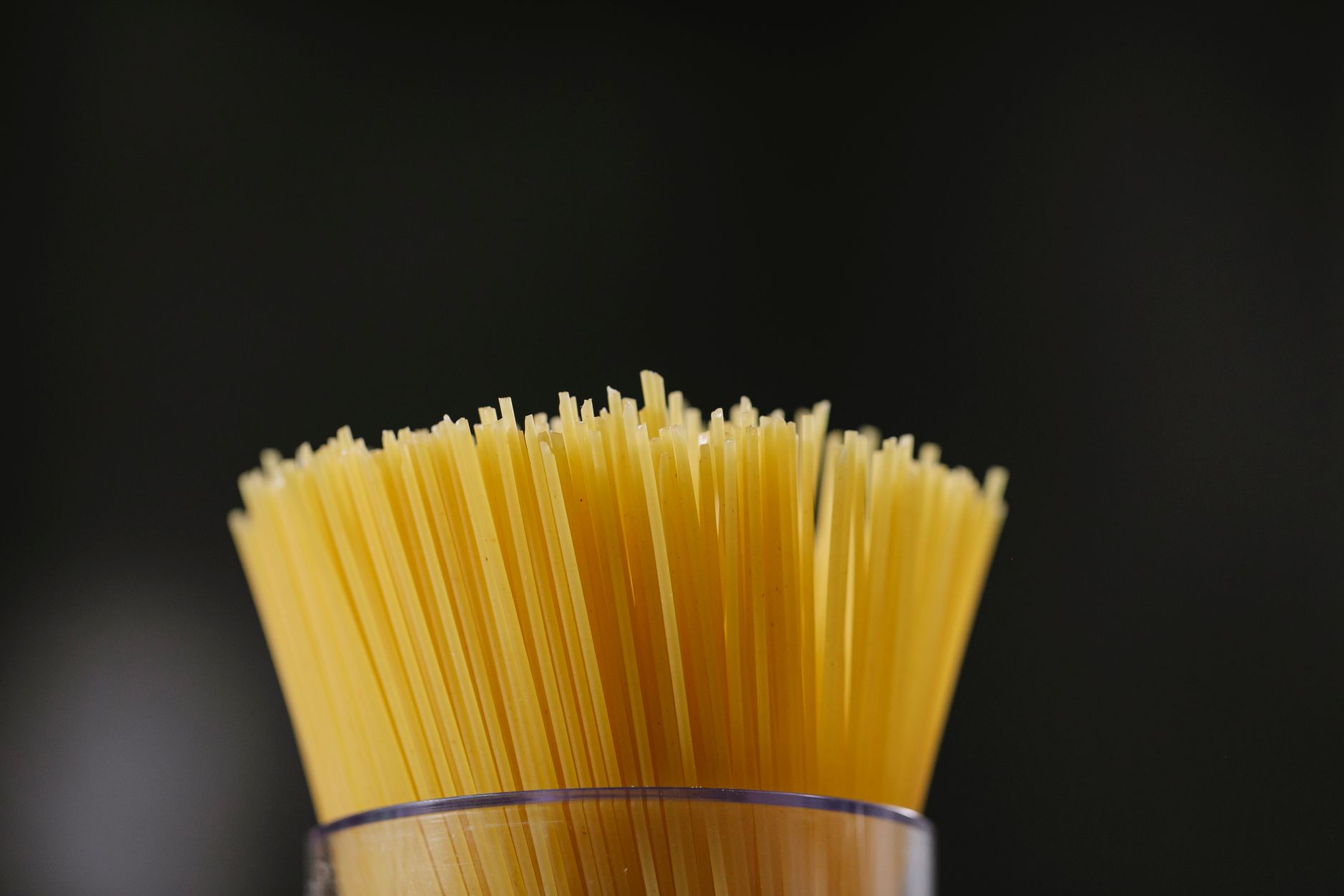 Spaghetti crudi disposti a ventaglio su un tavolo di legno