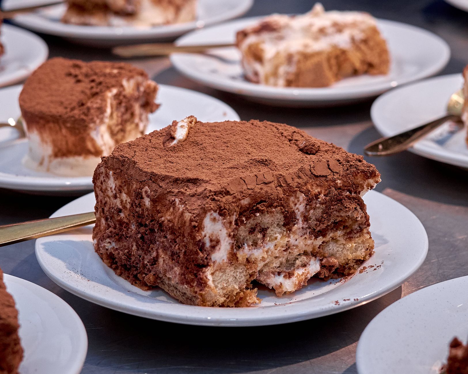 Preparazione del tiramisù con savoiardi inzuppati nel caffè