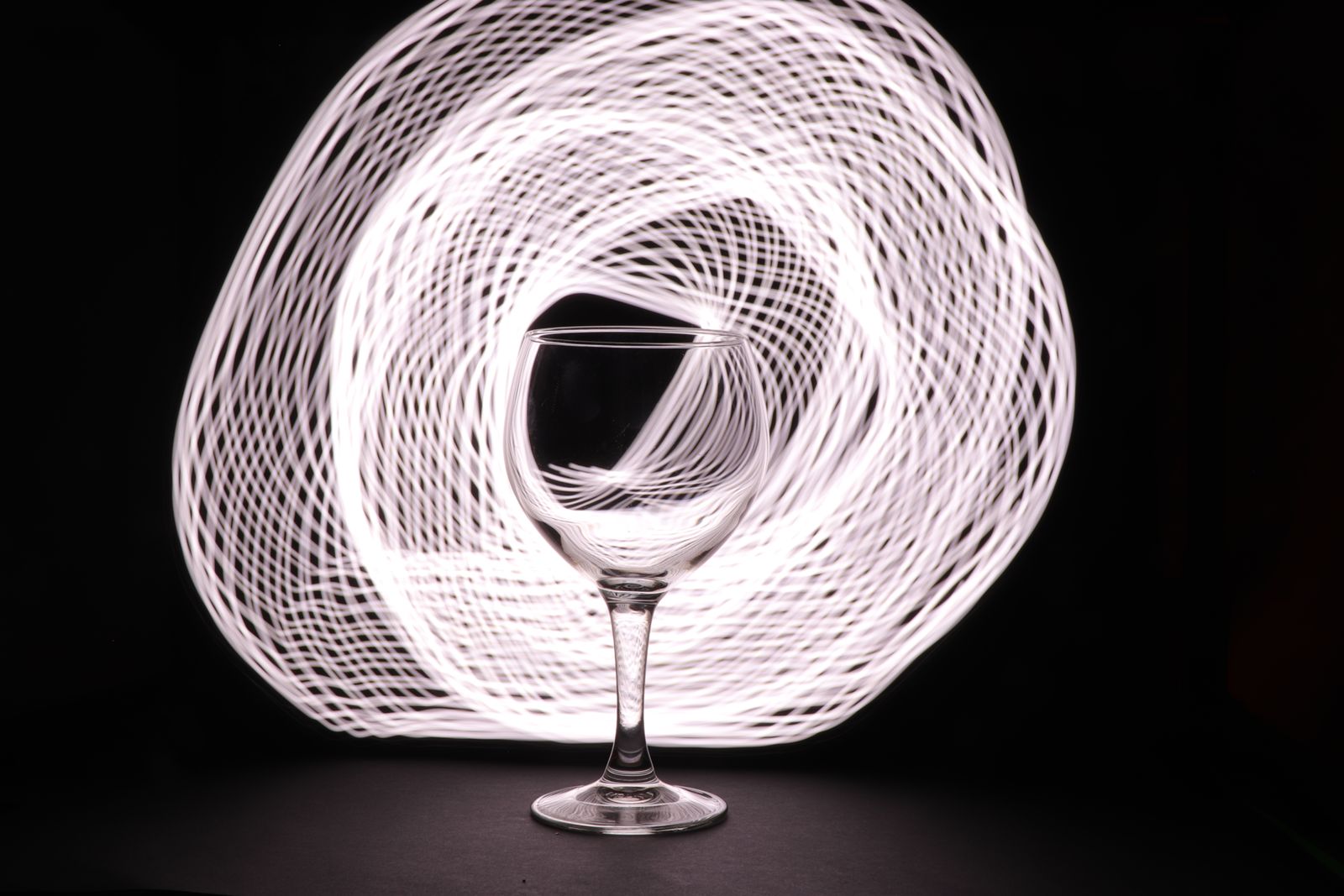 Calice di vino rosso inclinato con il velo di liquido sulla parete del bicchiere