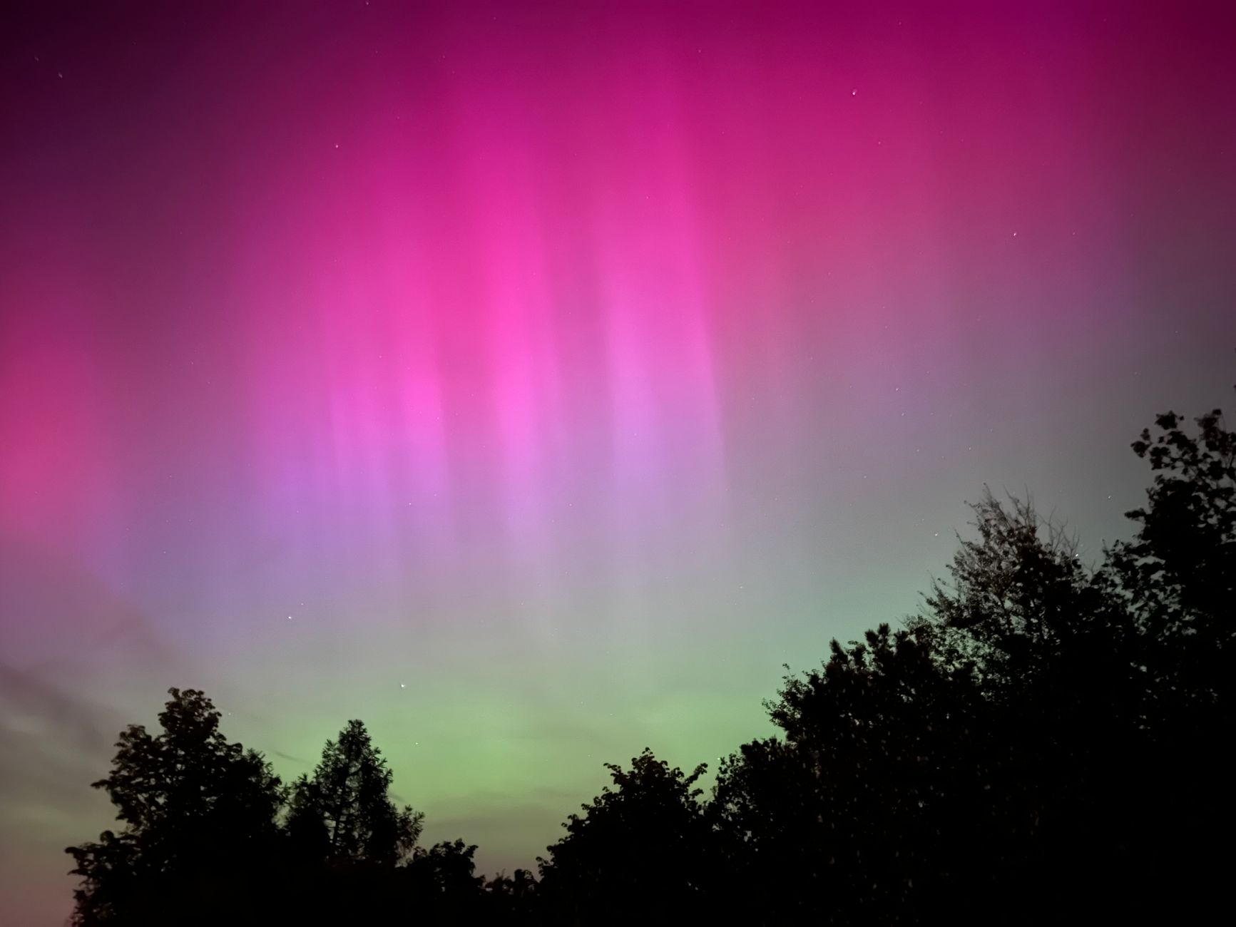 Tende luminose di aurora boreale riflesse su un lago