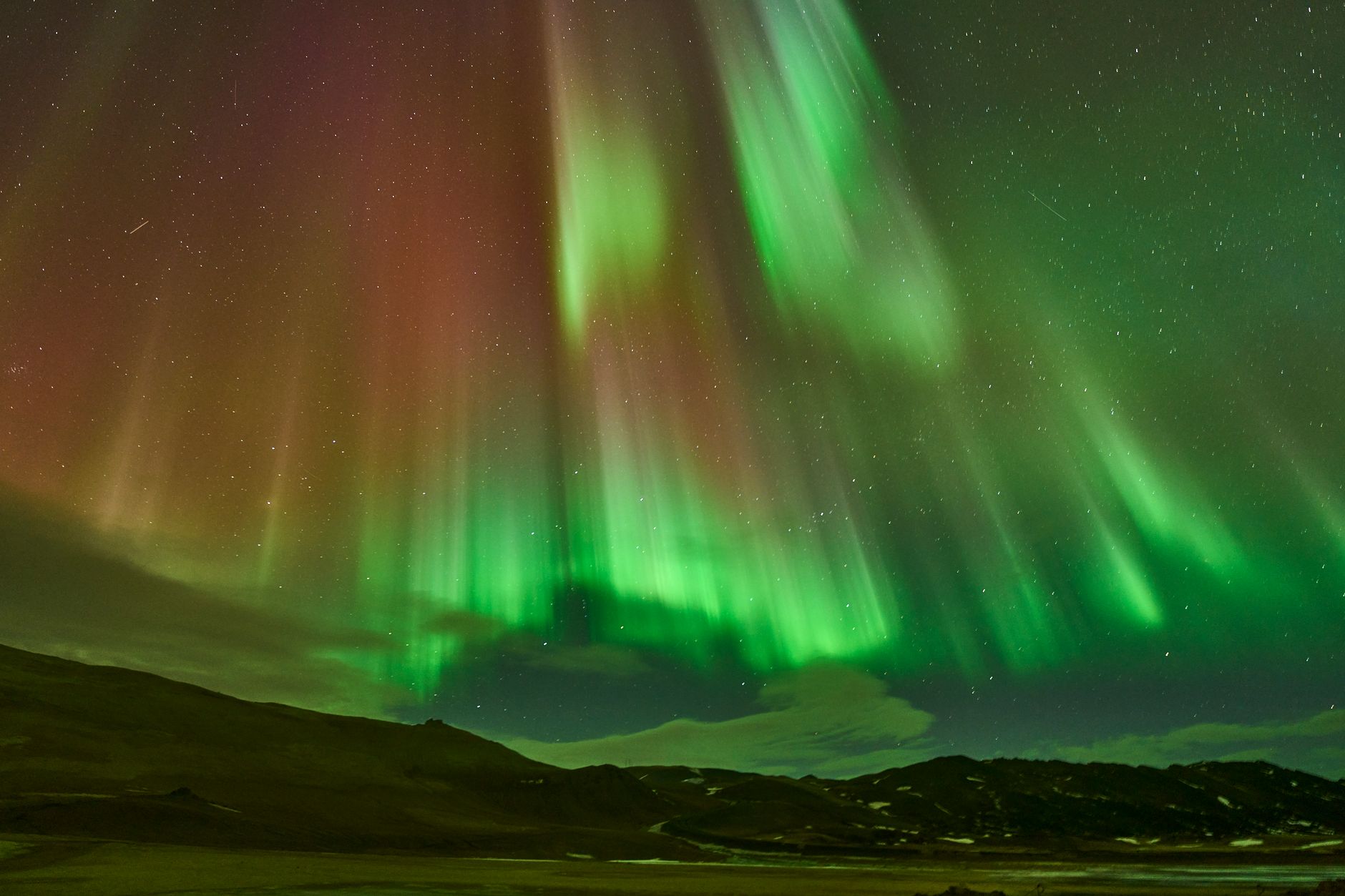 Aurora polare colorata sopra montagne al buio