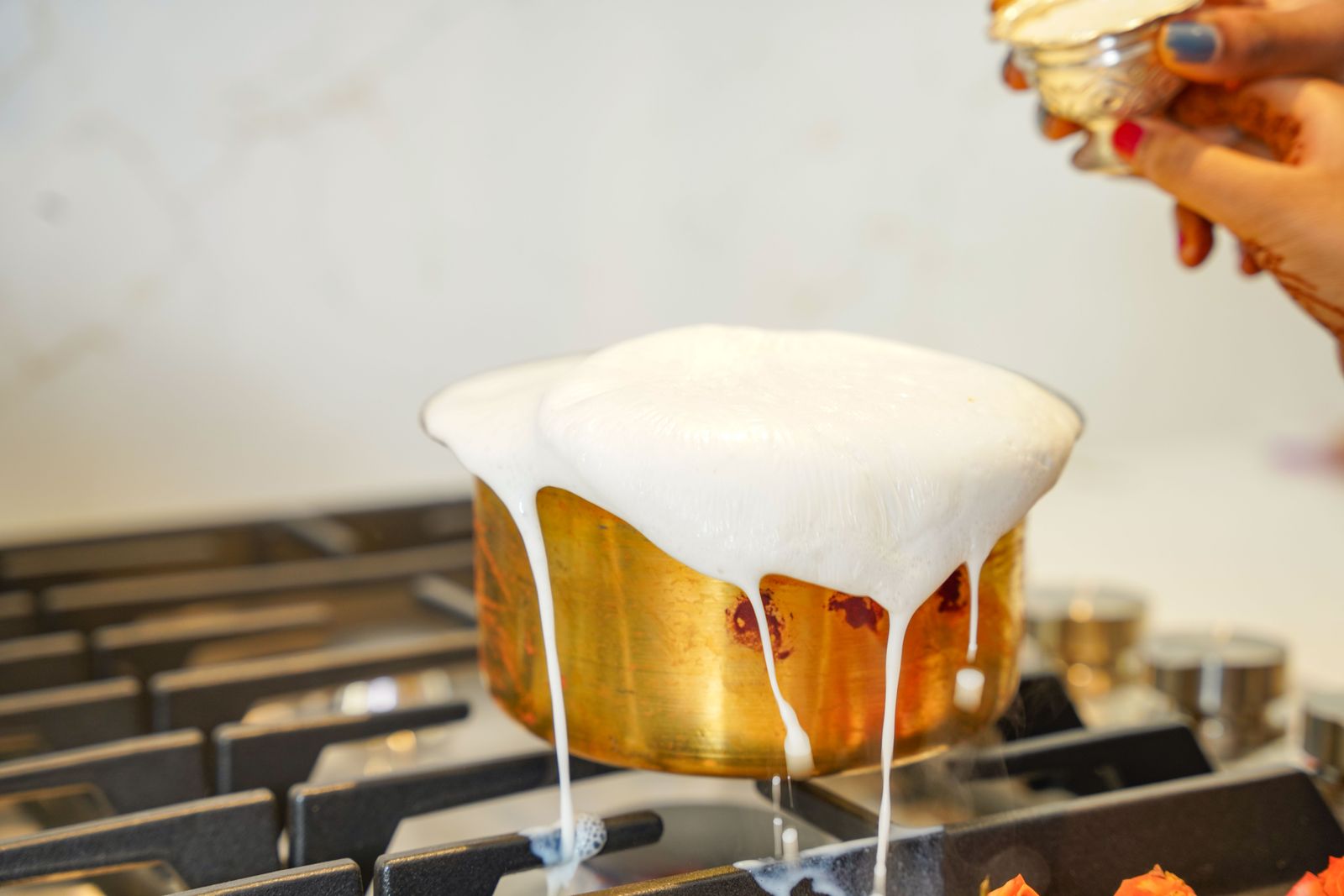 Pentolino di latte che trabocca sul fornello