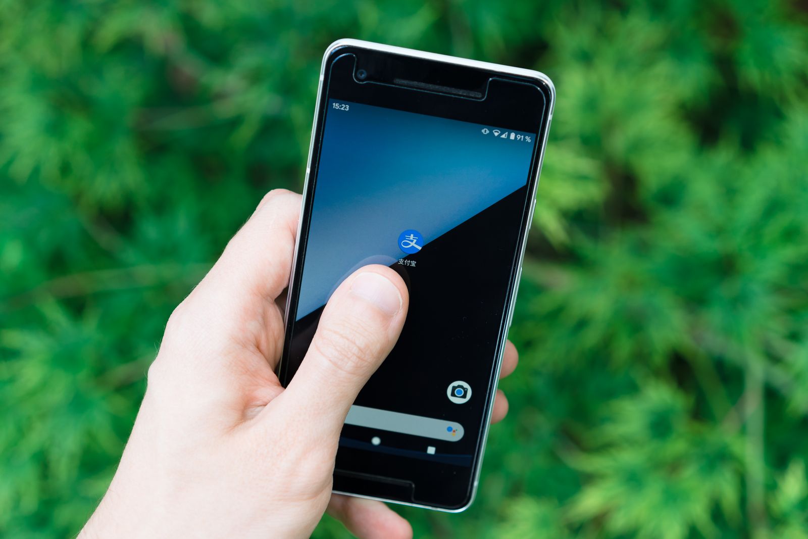 Una mano tiene uno smartphone con le app sullo schermo