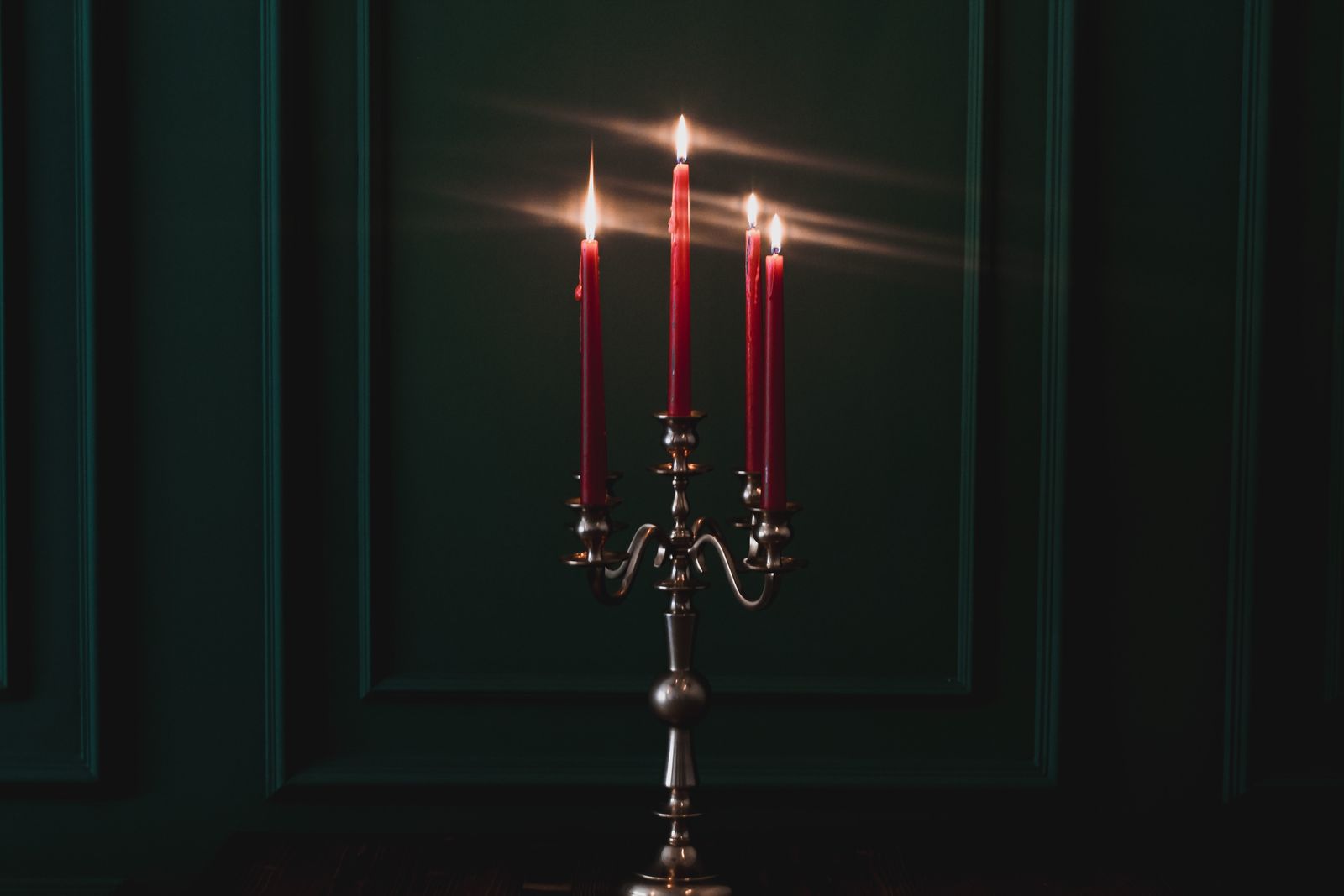 Candelabro con candele accese in una stanza buia, come le notti prima della luce elettrica