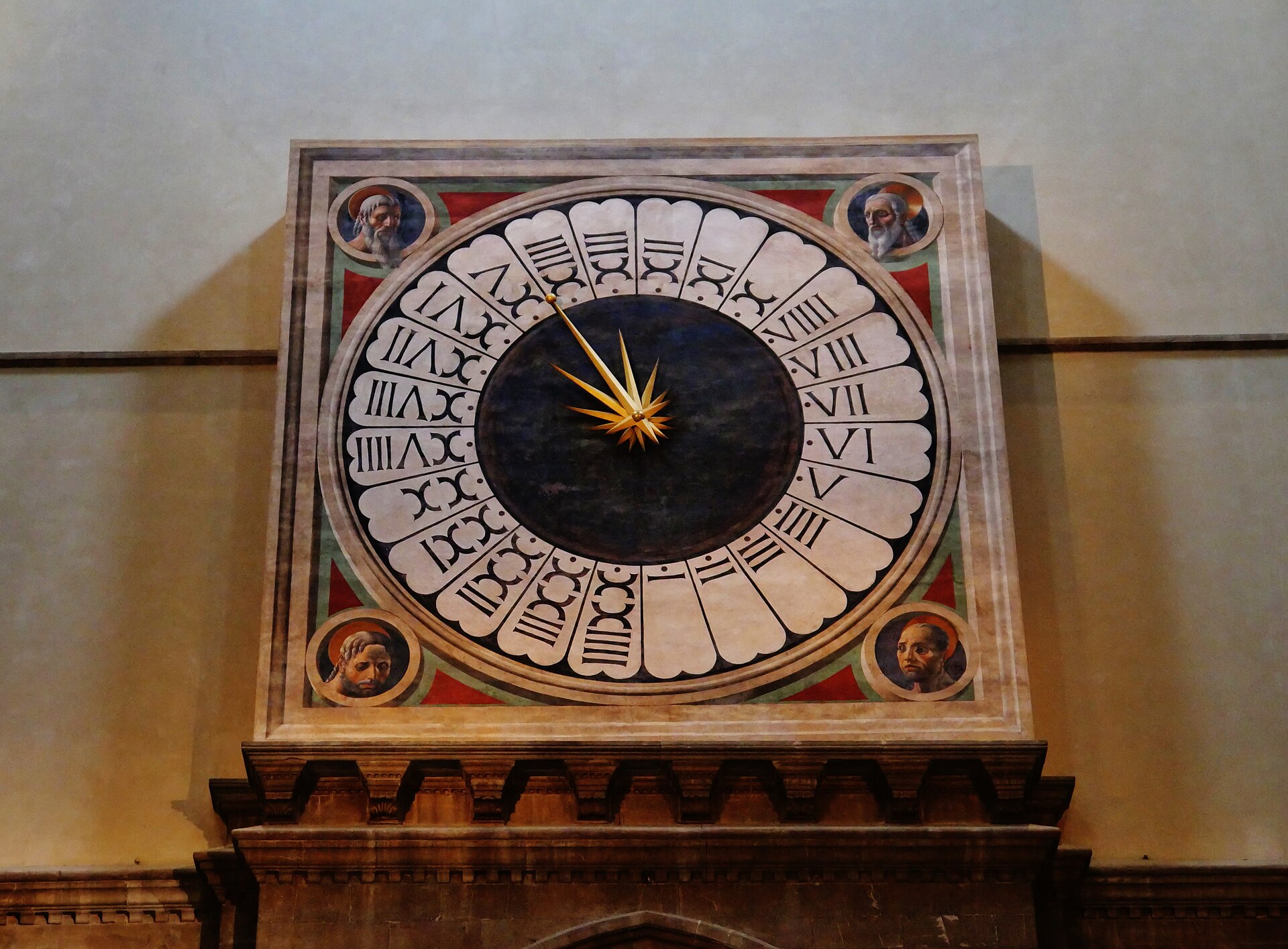 Il quadrante dell'orologio di Paolo Uccello nel Duomo di Firenze, con ventiquattro ore in numeri romani e quattro teste di santi agli angoli