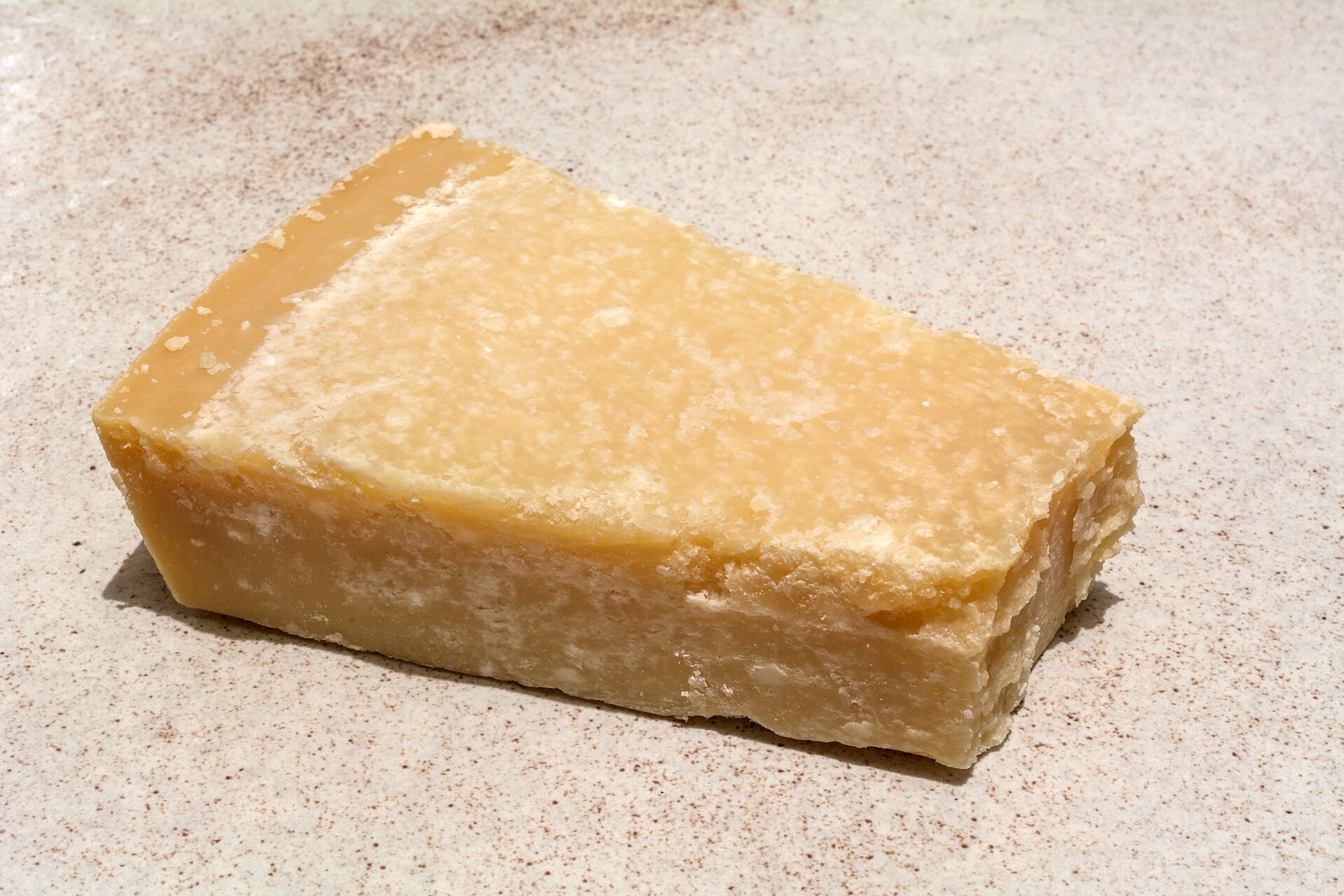 Pezzo di Parmigiano Reggiano stagionato con i puntini bianchi dei cristalli di tirosina nella pasta