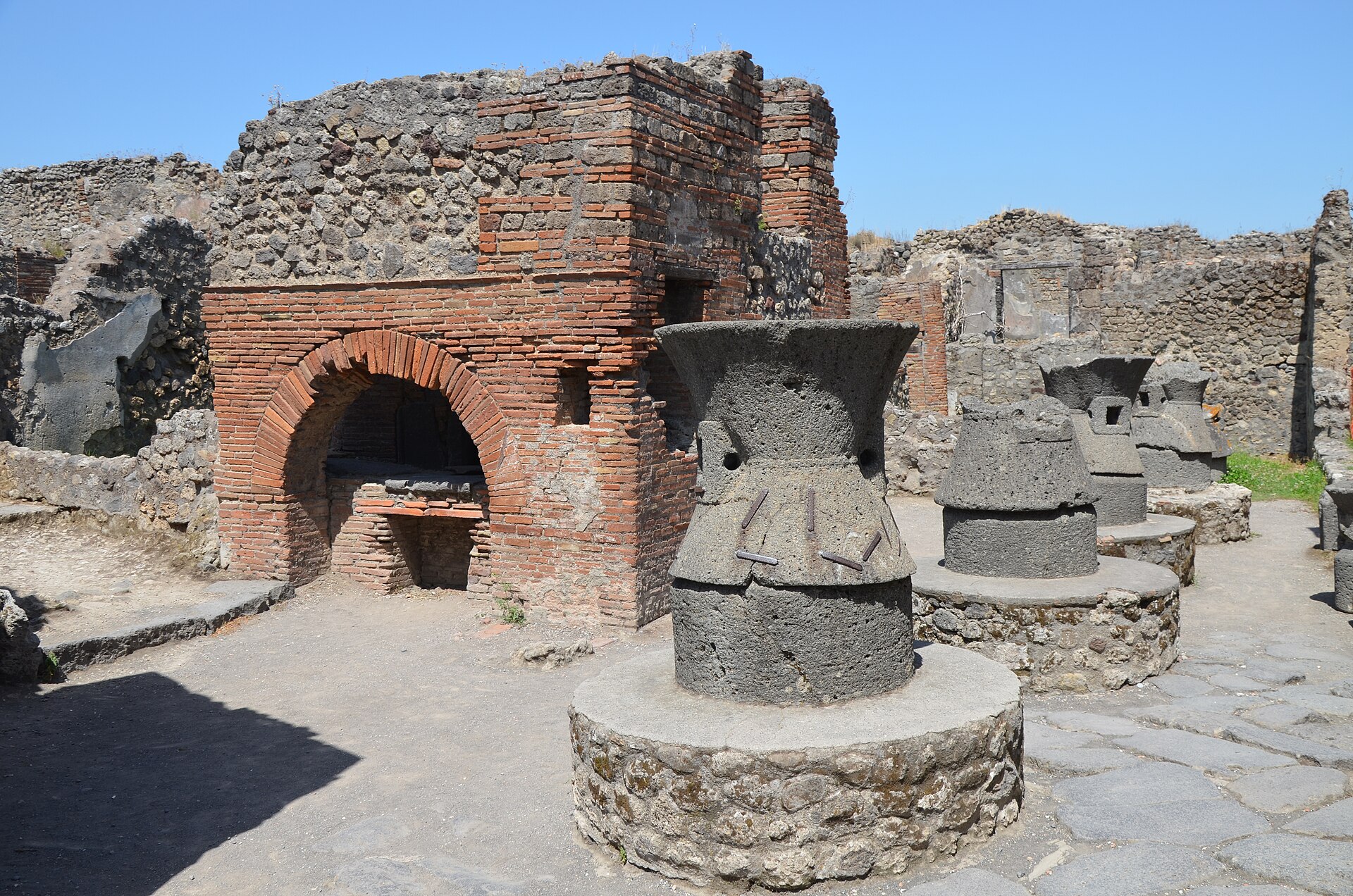 Macine in pietra lavica e banco di lavoro nel panificio romano di Vicolo Storto a Pompei