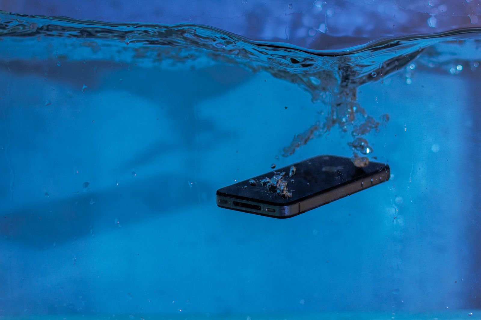 Uno smartphone sott'acqua circondato da bolle