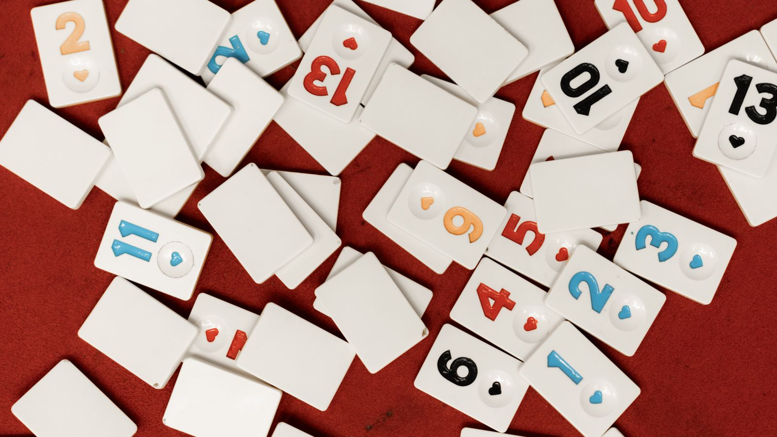 Tessere con lettere e numeri sparse su una superficie rossa