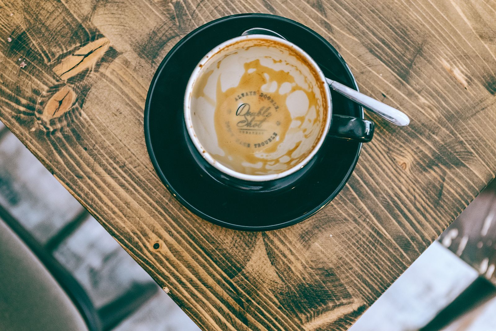 Tazzina di caffè vuota con il segno scuro del caffè sul fondo, su un tavolo di legno