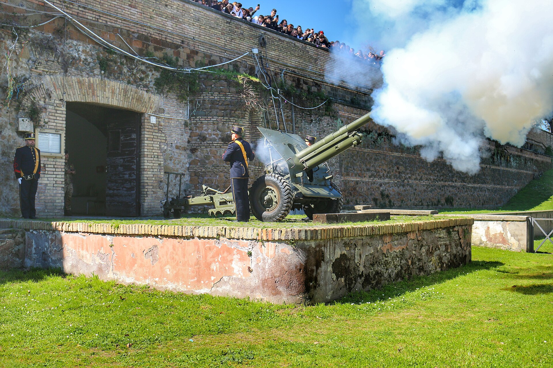 Artiglieri in uniforme storica sparano il colpo di mezzogiorno con il cannone del Gianicolo a Roma, tra il fumo bianco