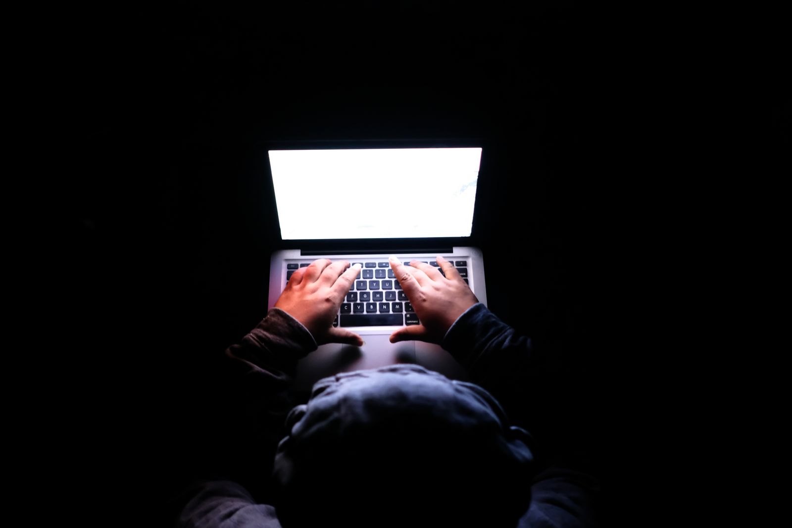Persona che usa un portatile in una stanza buia
