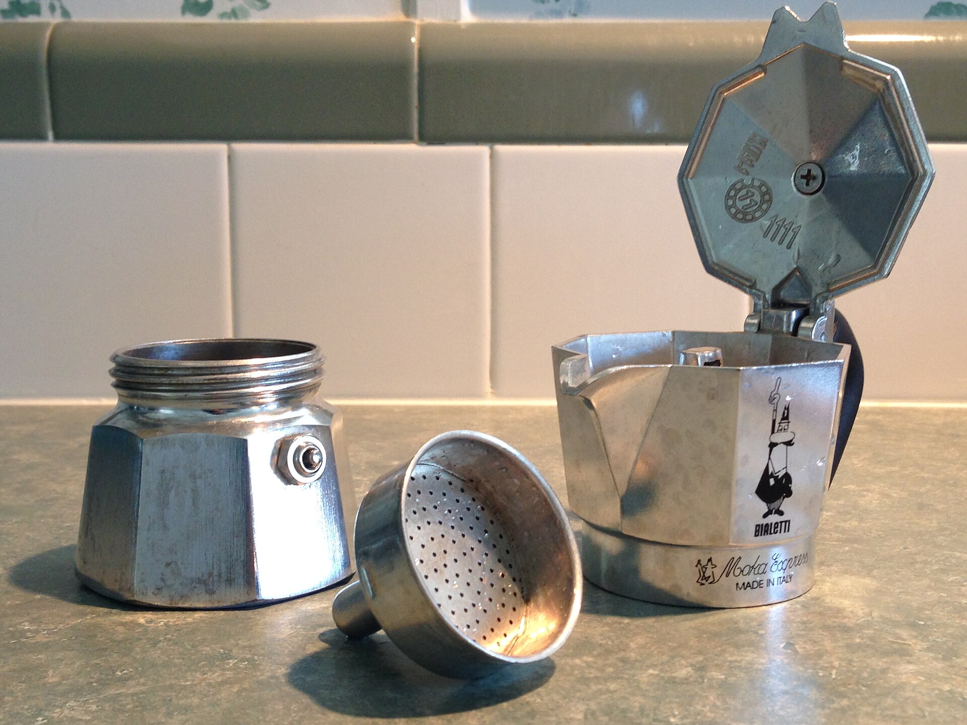 Moka Express Bialetti smontata: caldaia con valvola di sicurezza, imbuto filtro e raccoglitore ottagonale
